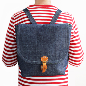 Fiona modelling the Bropmton Bag in a backpack form, shown on her back in a blue denim fabric.