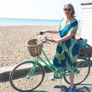 Fiona on a bike on the seafront at Worthing, wearing in her Cecily dress